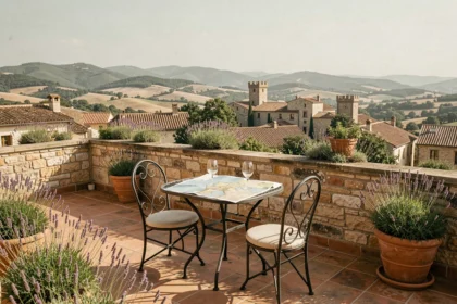 Terrasse ensoleillée d'un hôtel de luxe en Occitanie avec vue sur les collines et les toits médiévaux